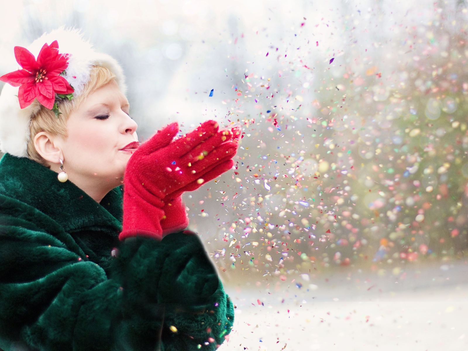 Женщина в шубе сдувает конфетти с ладоней