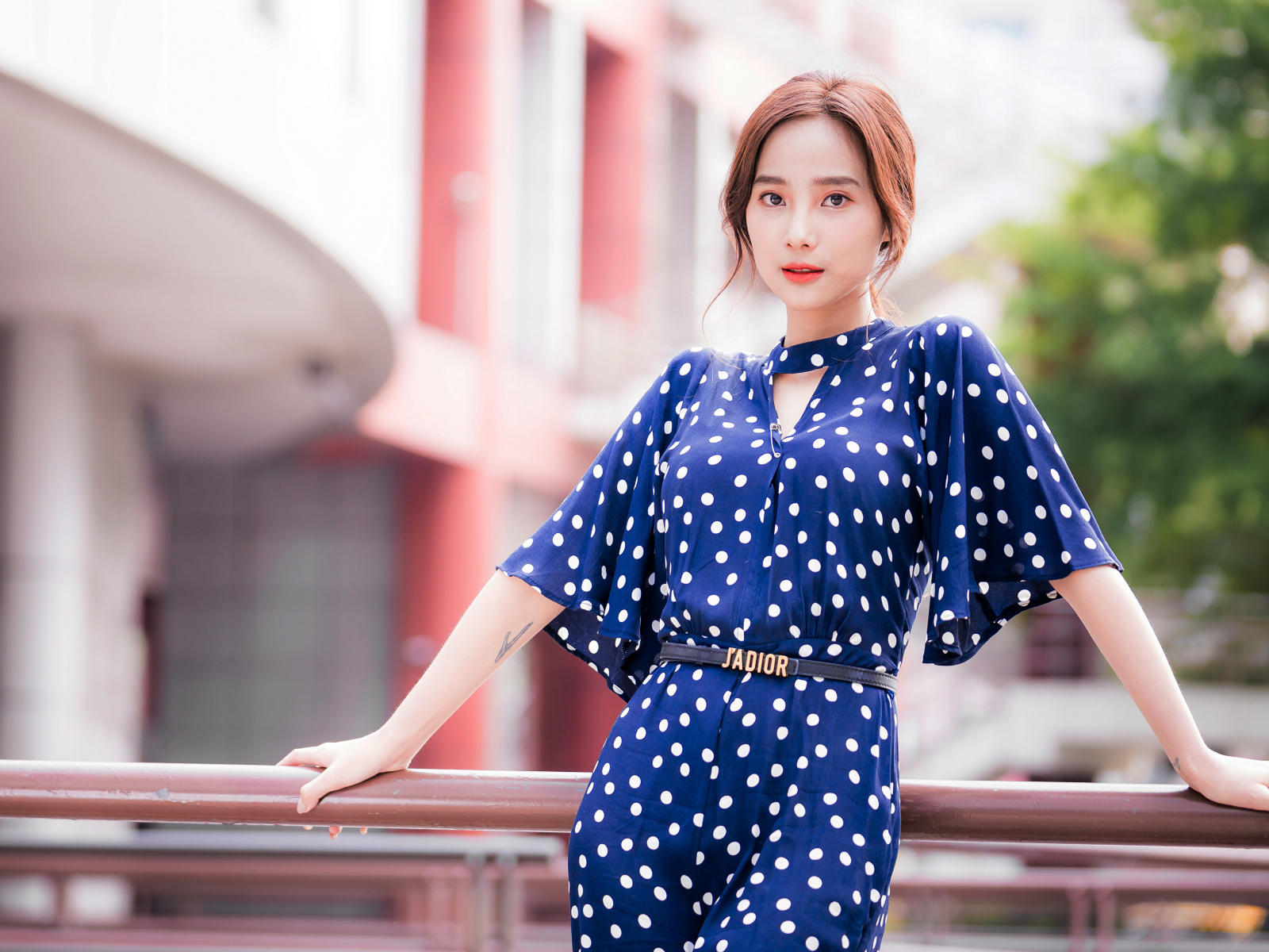 Девушка азиатка в синем платье в белый горошек