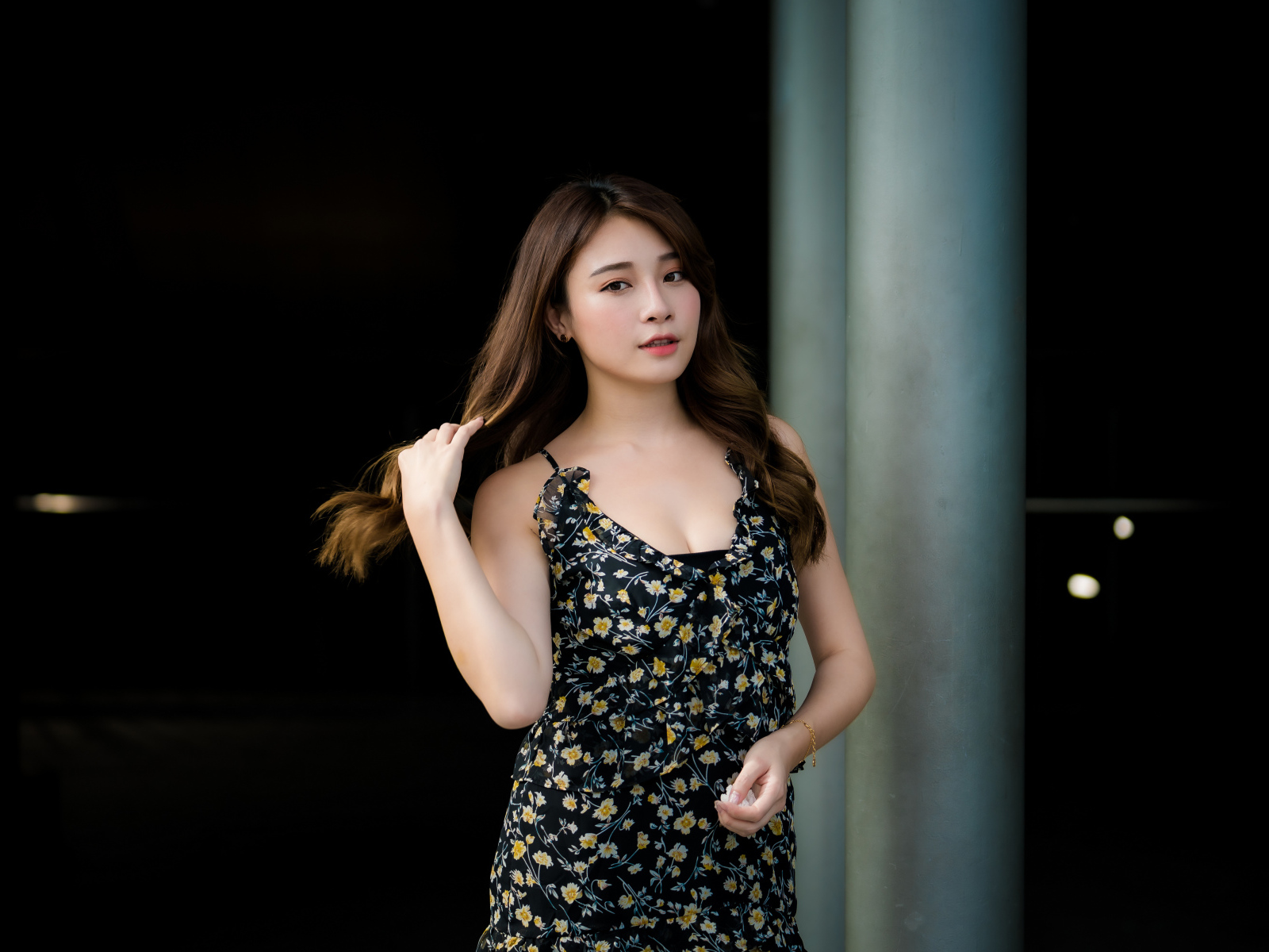 Девушка азиатка в платье трогает волосы 