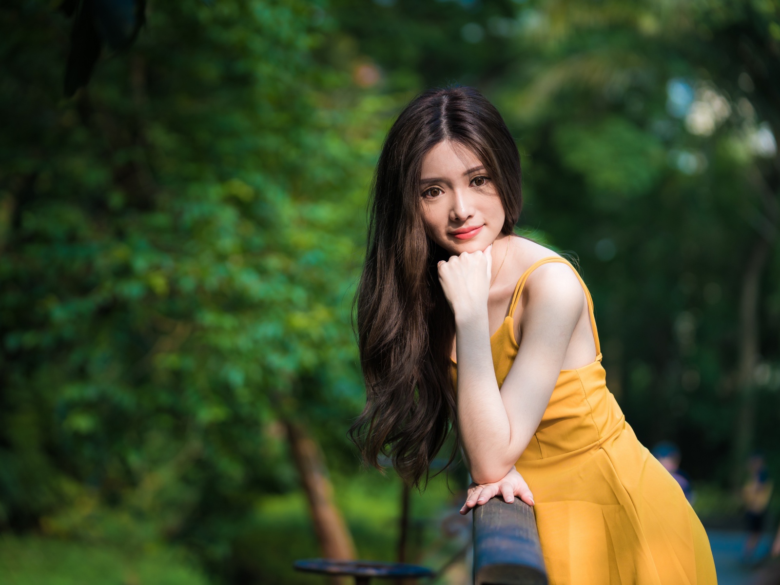 Девушка азиатка с большими карими глазами в желтом платье 