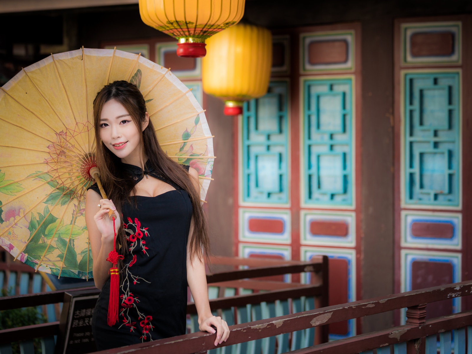 Красивая девушка азиатка в черном платье с зонтом