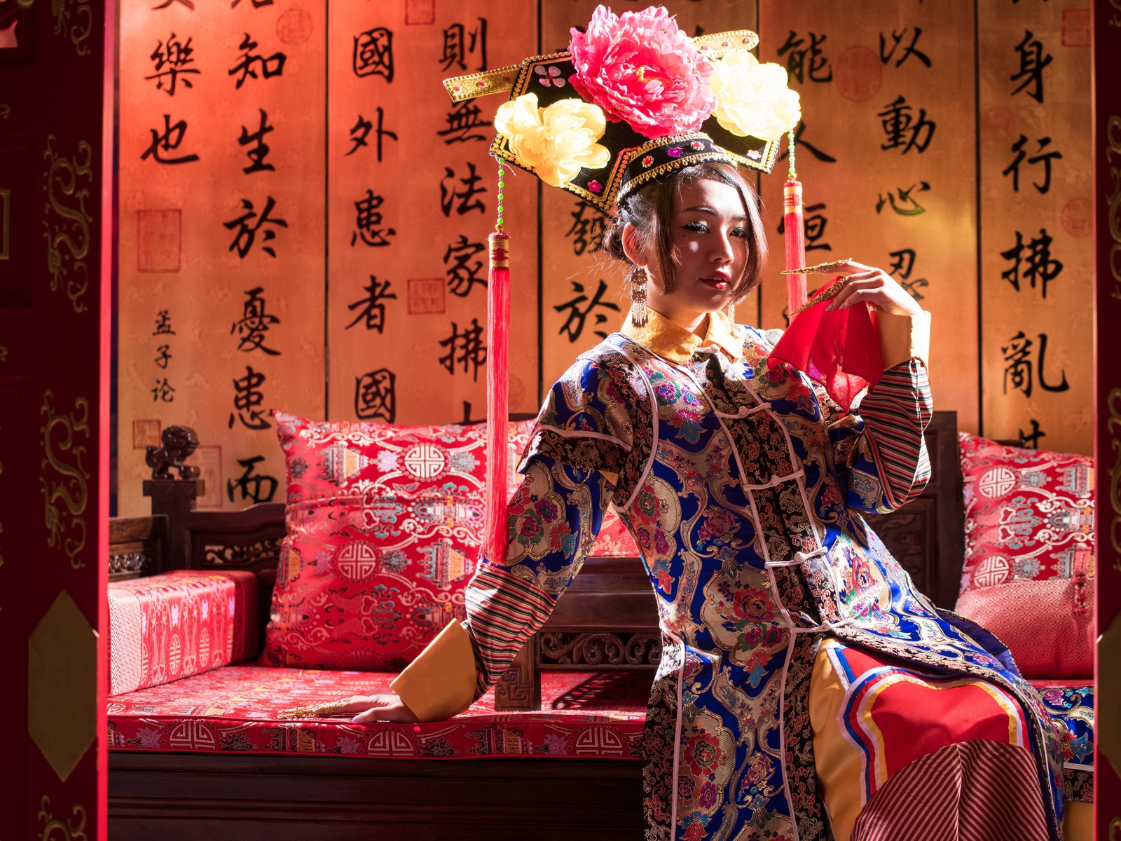 Красивая девушка азиатка в национальном костюме на диване