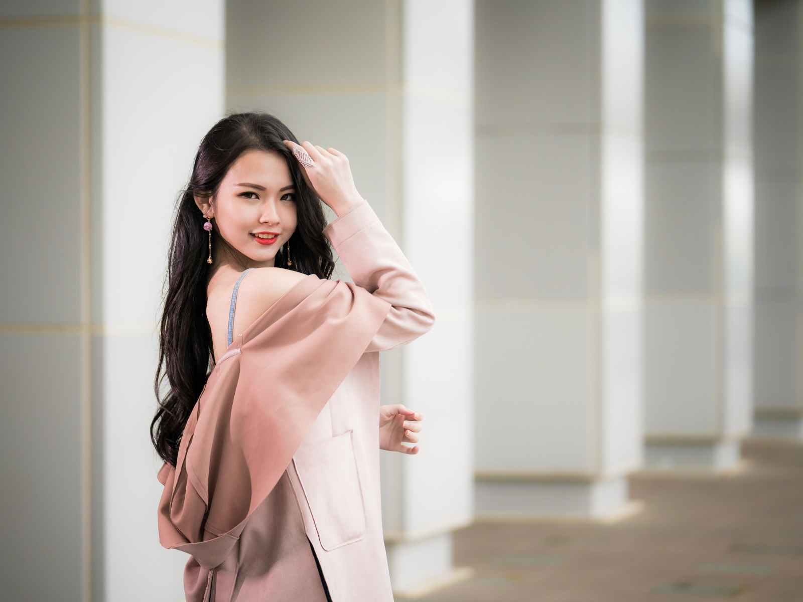 Красивая девушка азиатка с длинными волосами в розовом пальто 