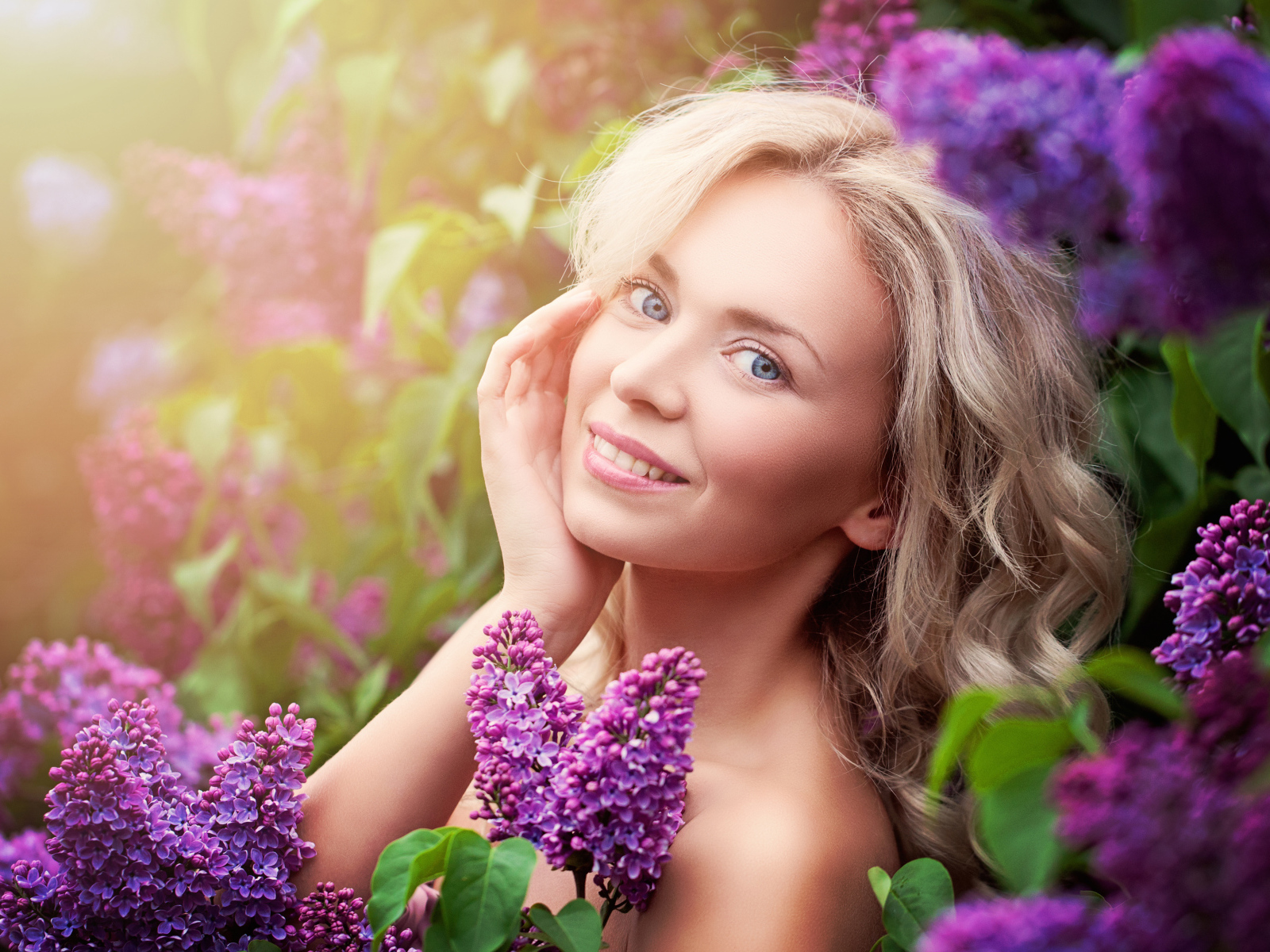 Красивая голубоглазая девушка блондинка в цветах сирени