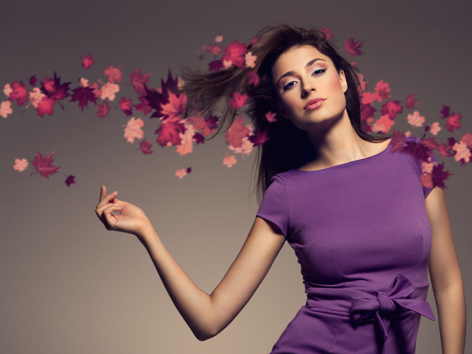 Красивая девушка в фиолетовом платье на сером фоне 