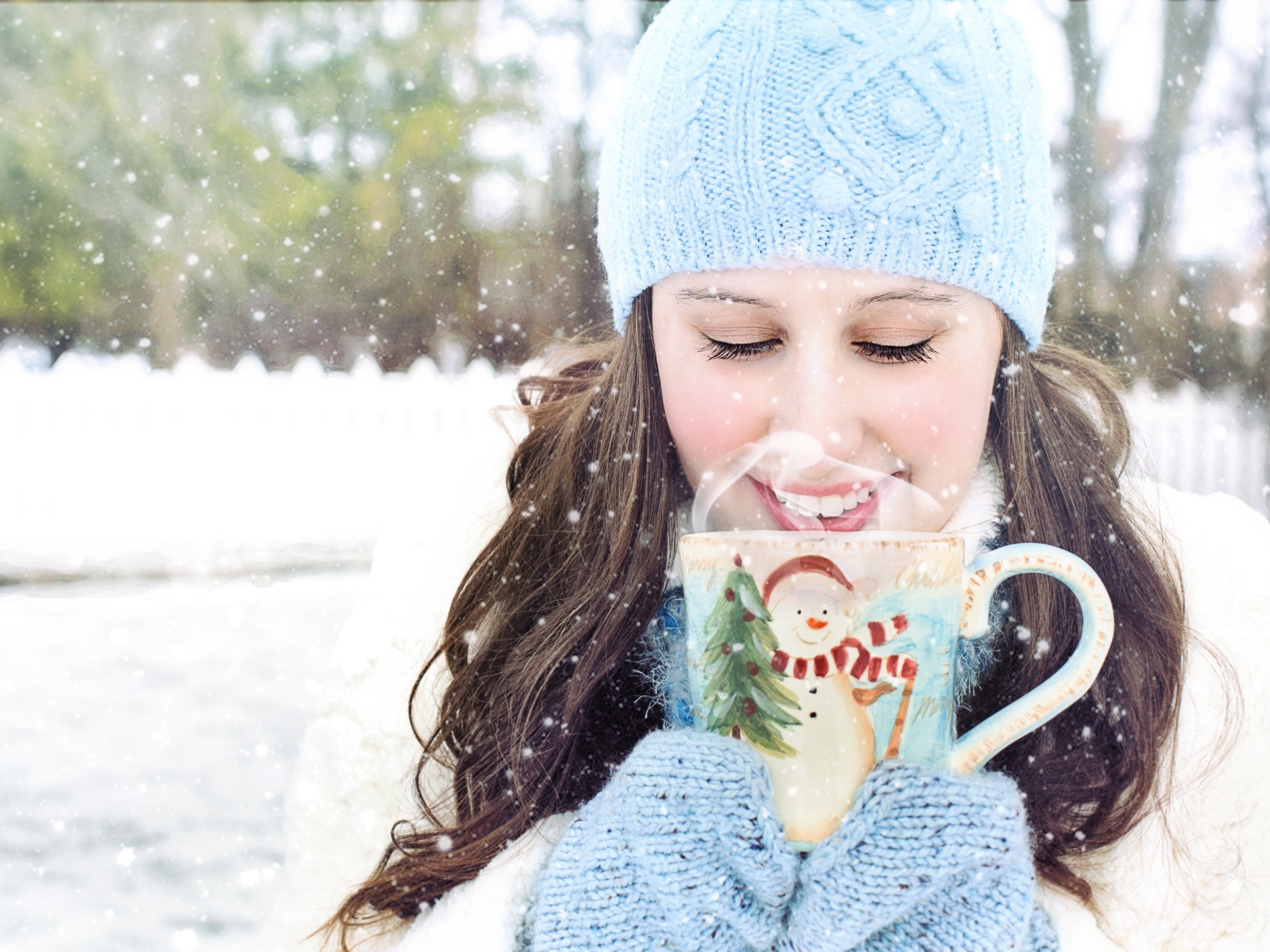 Красивая девушка с чашкой горячего кофе на улице зимой