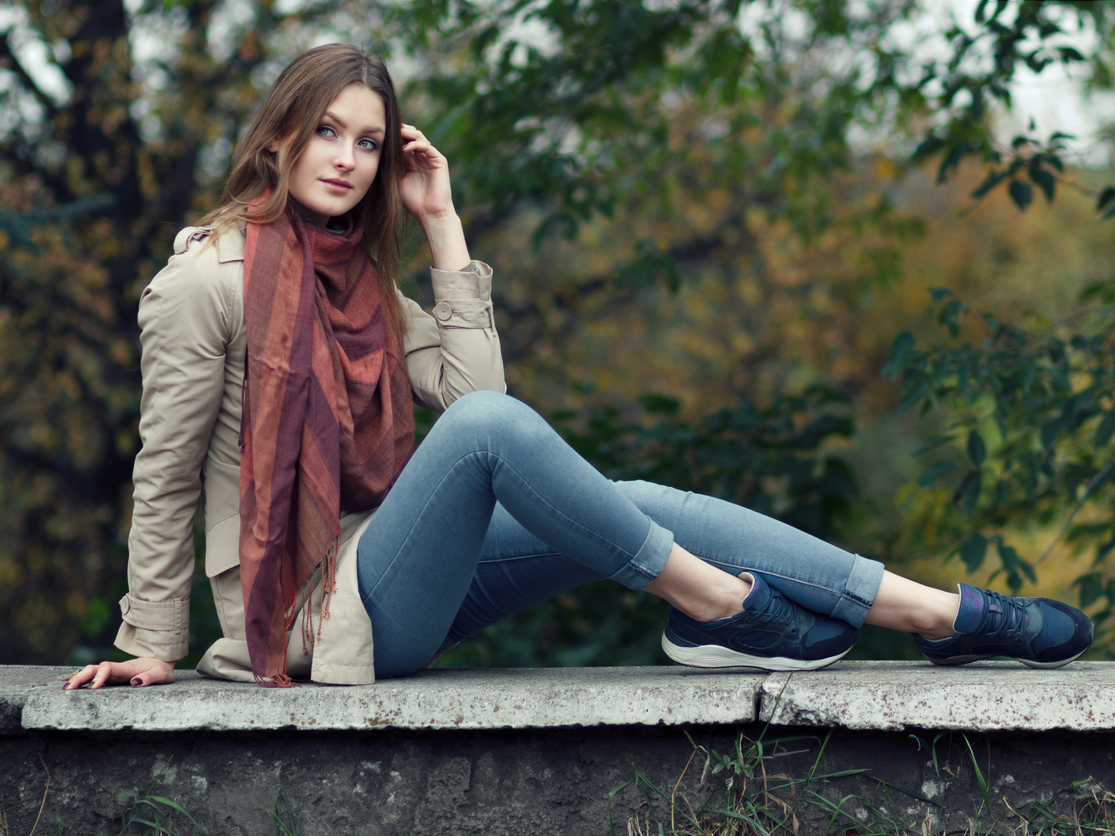 Милая девушка в куртке и синих джинсах 