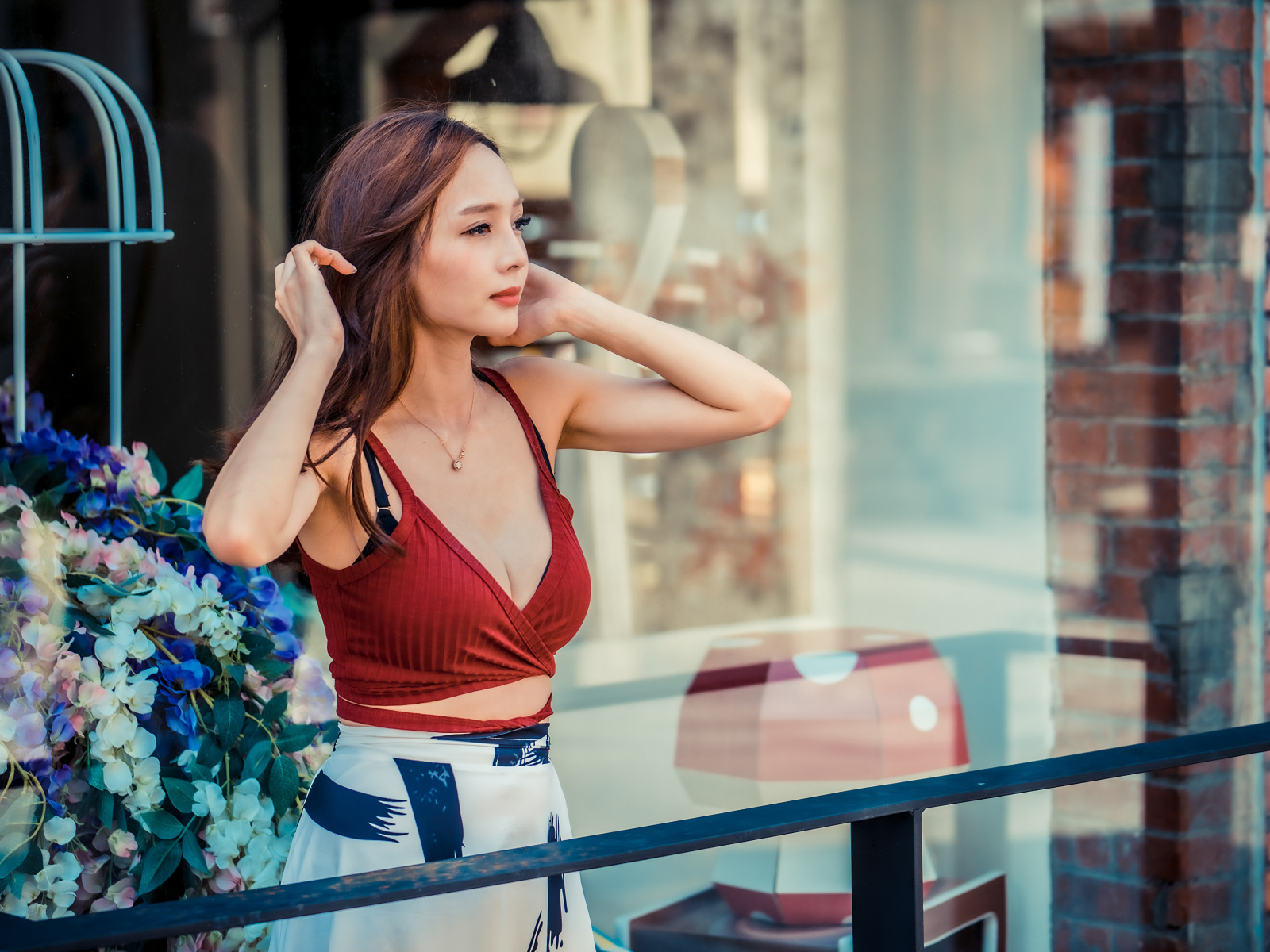 Нежная девушка азиатка стоит на балконе 