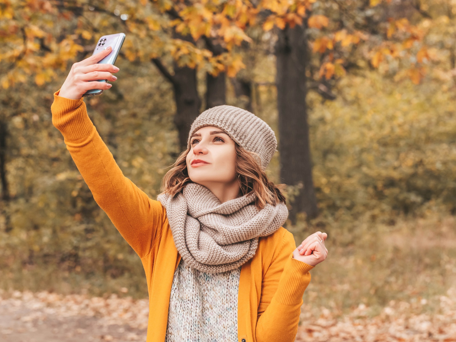 Девушка делает селфи на улице осенью 