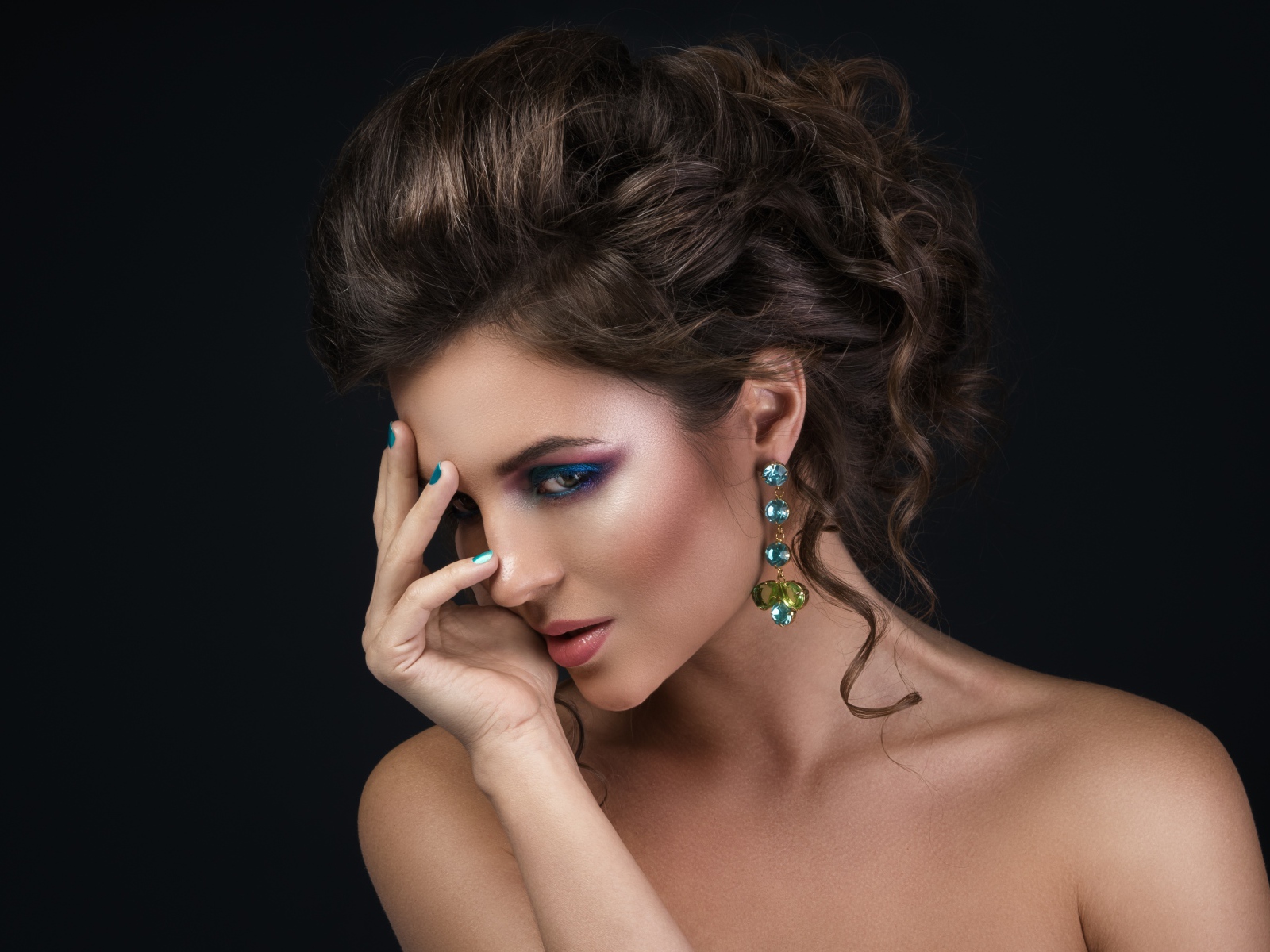 Девушка с красивой вечерней прической на сером фоне