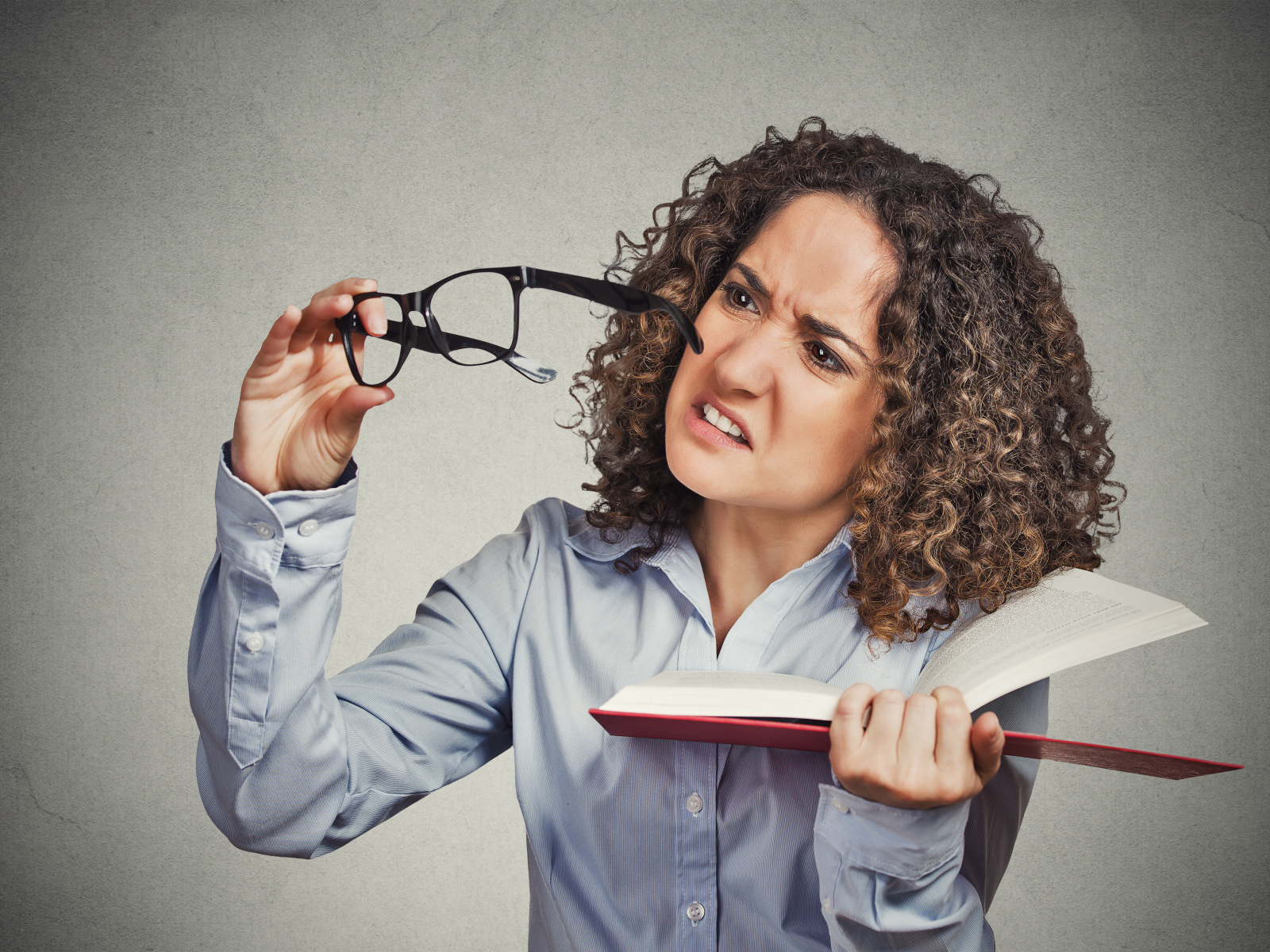 Девушка с книгой с очками в руке