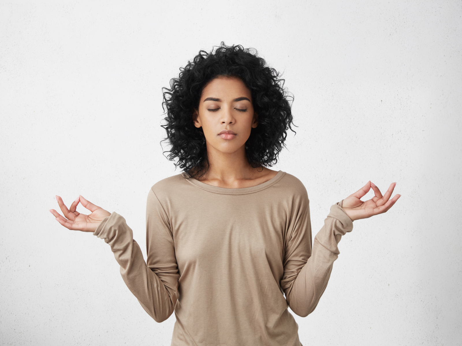 Девушка с закрытыми глазами медитирует 