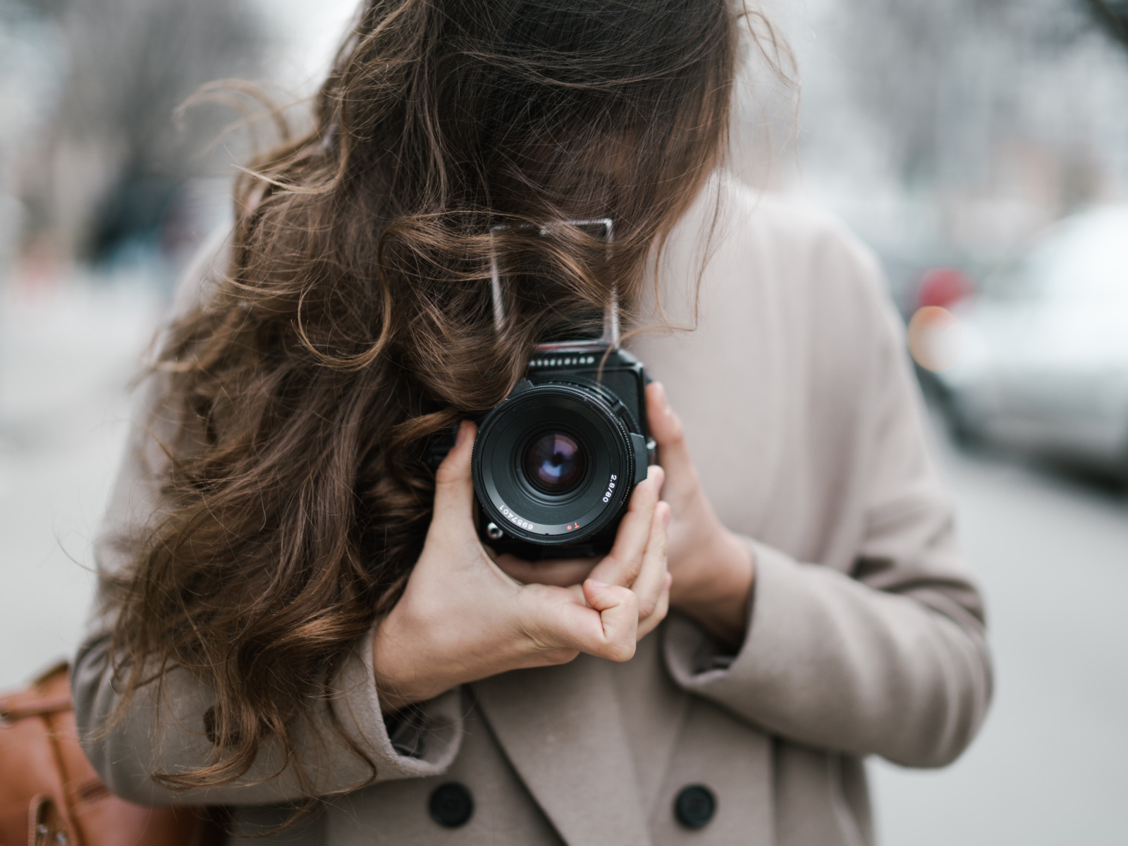 Длинноволосая девушка с фотоаппаратом в руках 