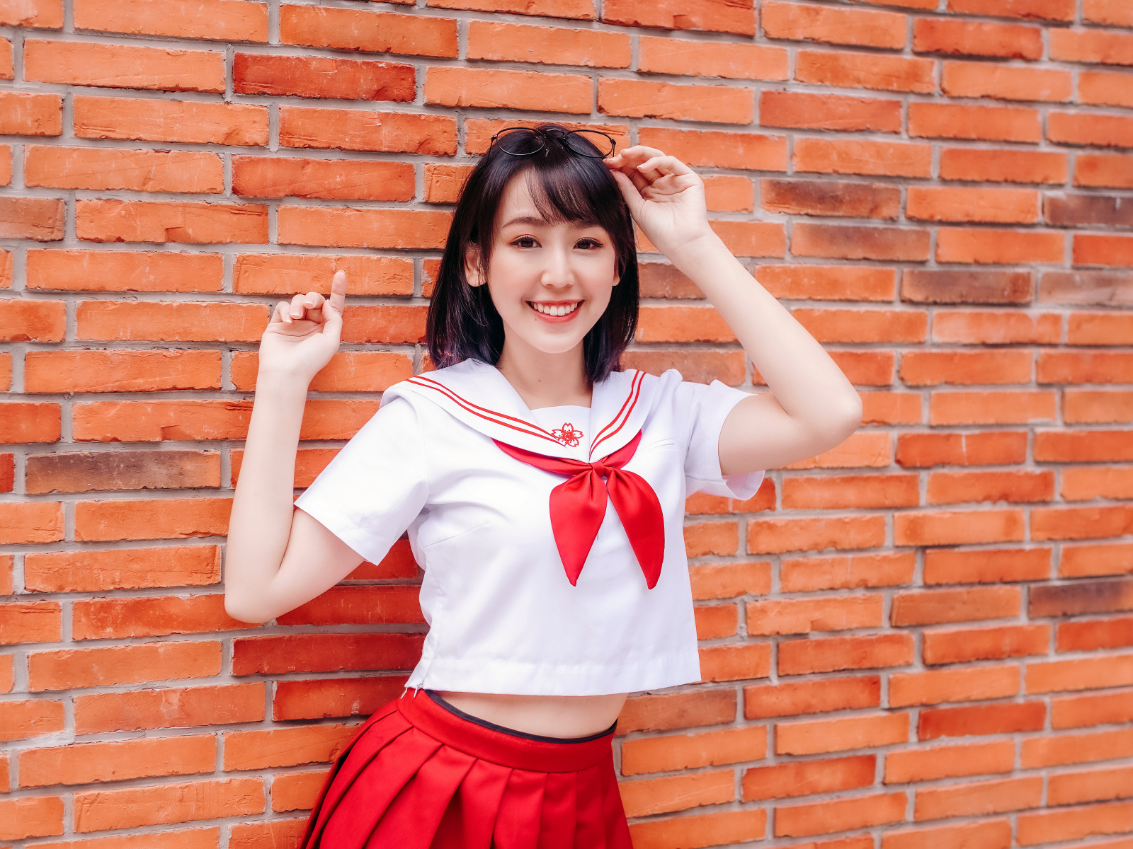 Улыбающаяся азиатка стоит у стены 