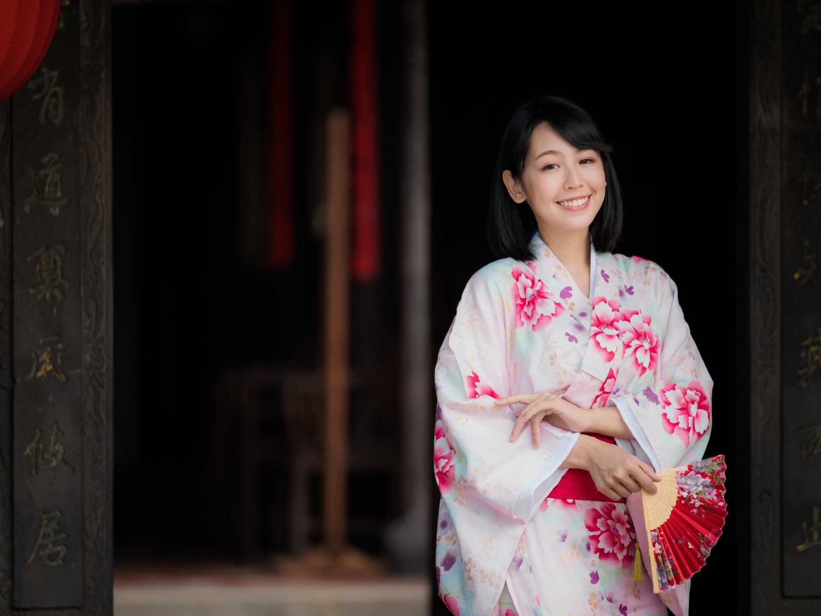 Улыбающаяся девушка азиатка в кимоно с веером в руке