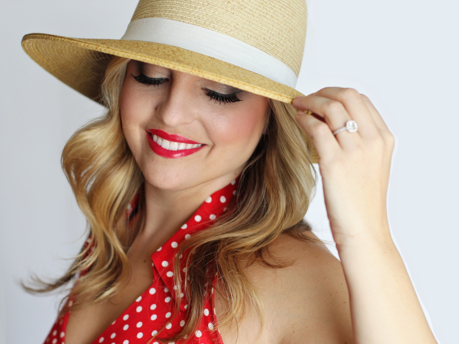Улыбающаяся девушка в шляпе на белом фоне