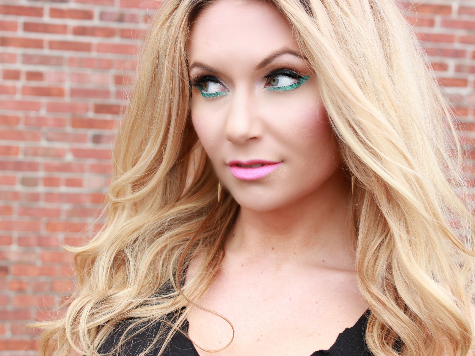 Эффектная длинноволосая блондинка у стены 