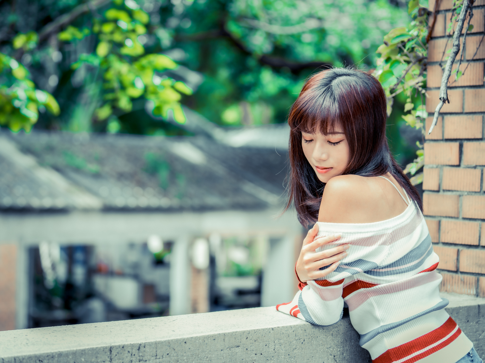 Нежная азиатка стоит на балконе