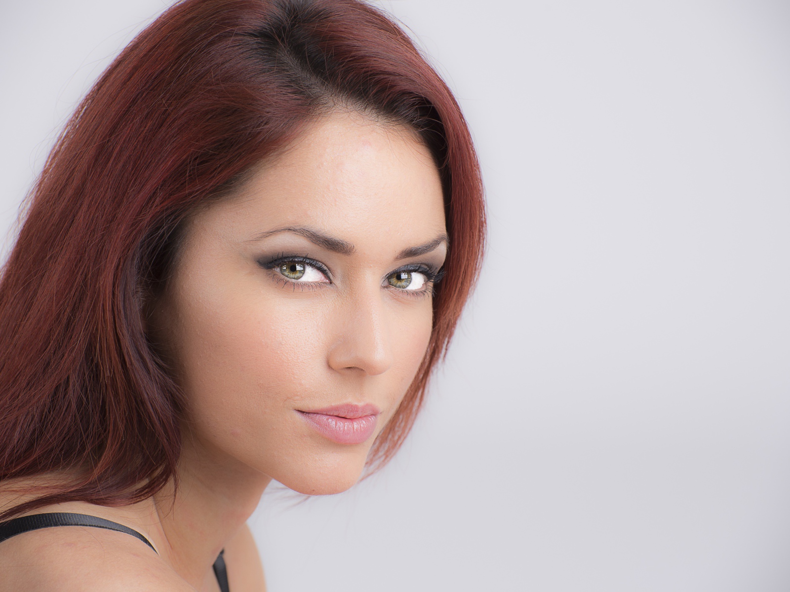 Лицо стильной девушки с зелеными глазами на сером фоне