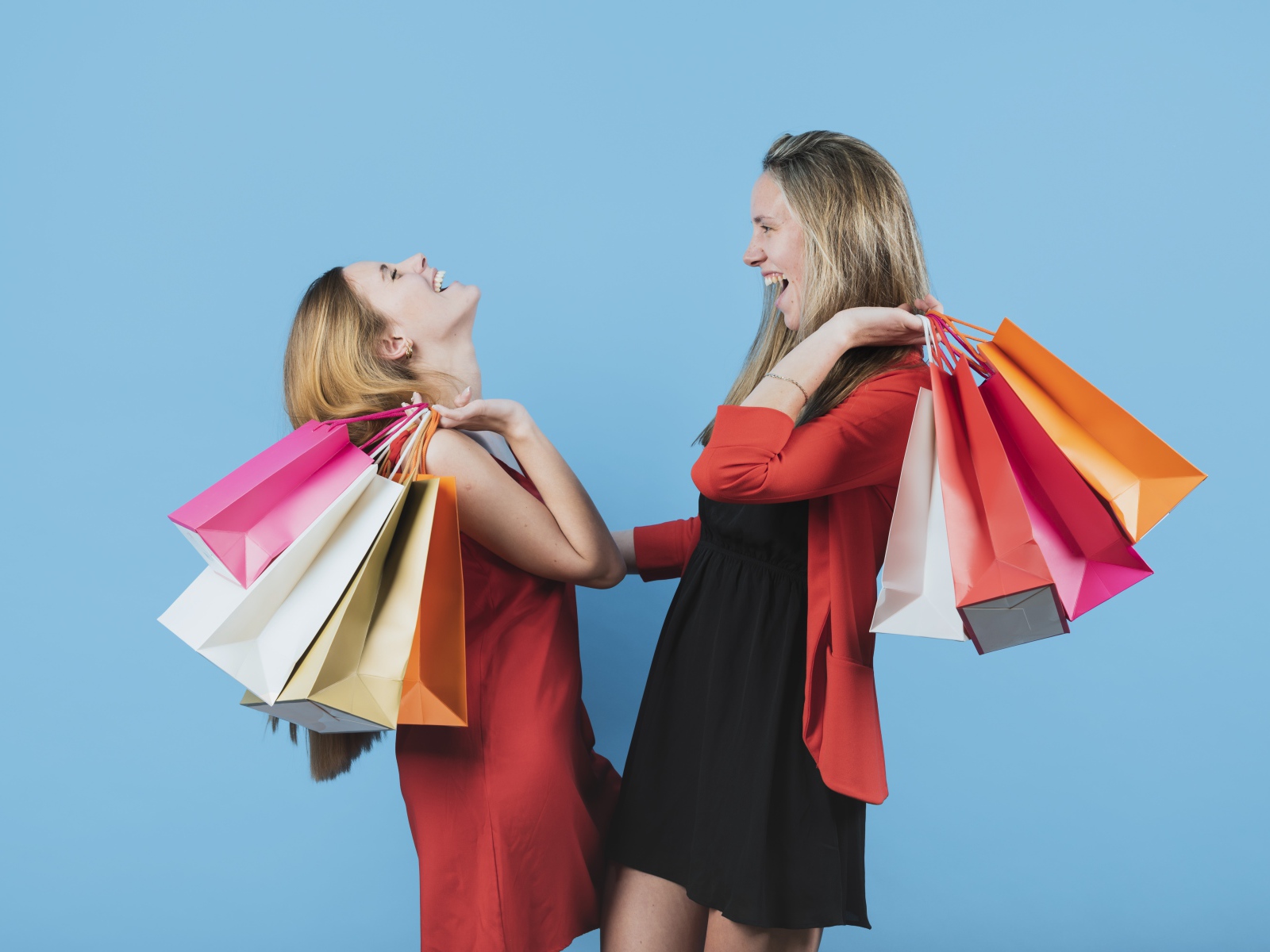 Две девушки с покупками на голубом фоне