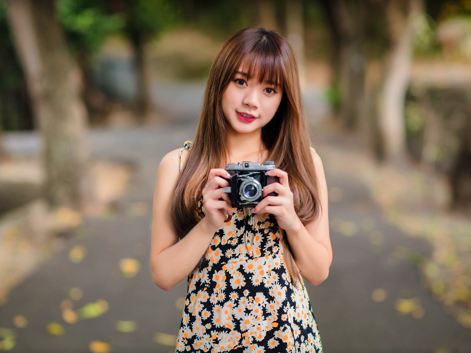 Молодая девушка азиатка с фотоаппаратом в руках 