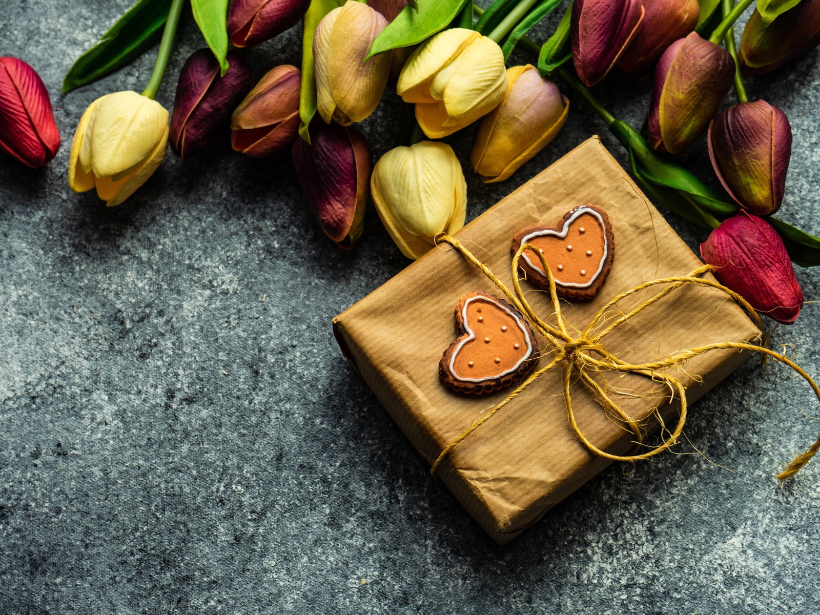 Подарок с букетом тюльпанов на сером столе