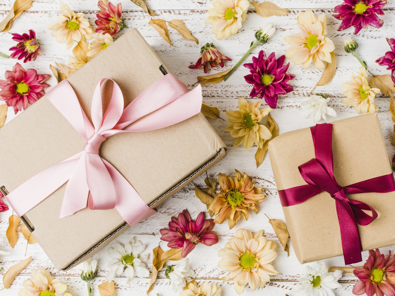Две коробки с подарками на столе с цветами хризантемы
