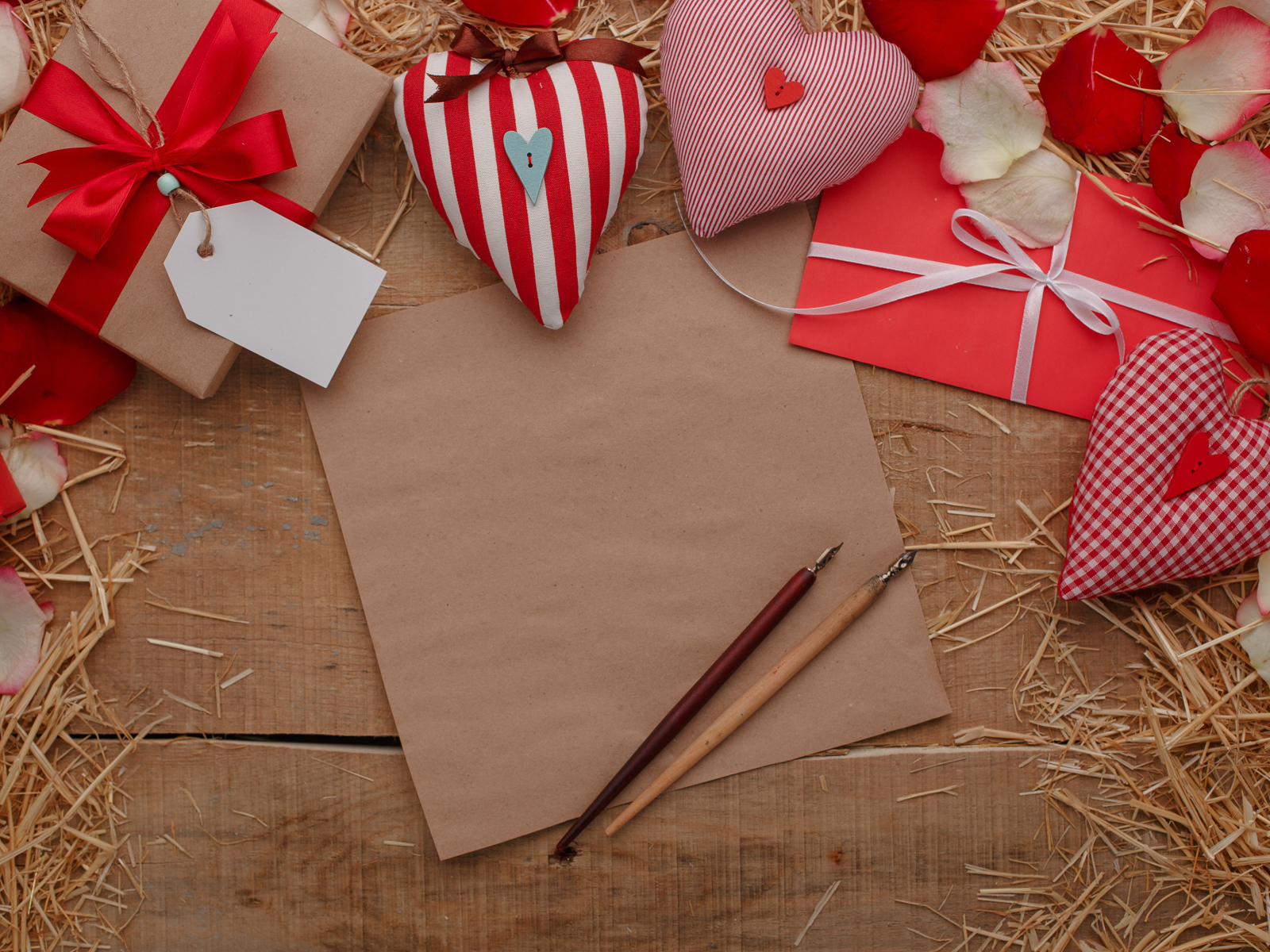 Сердечки из ткани на столе с бумагой и подарками 