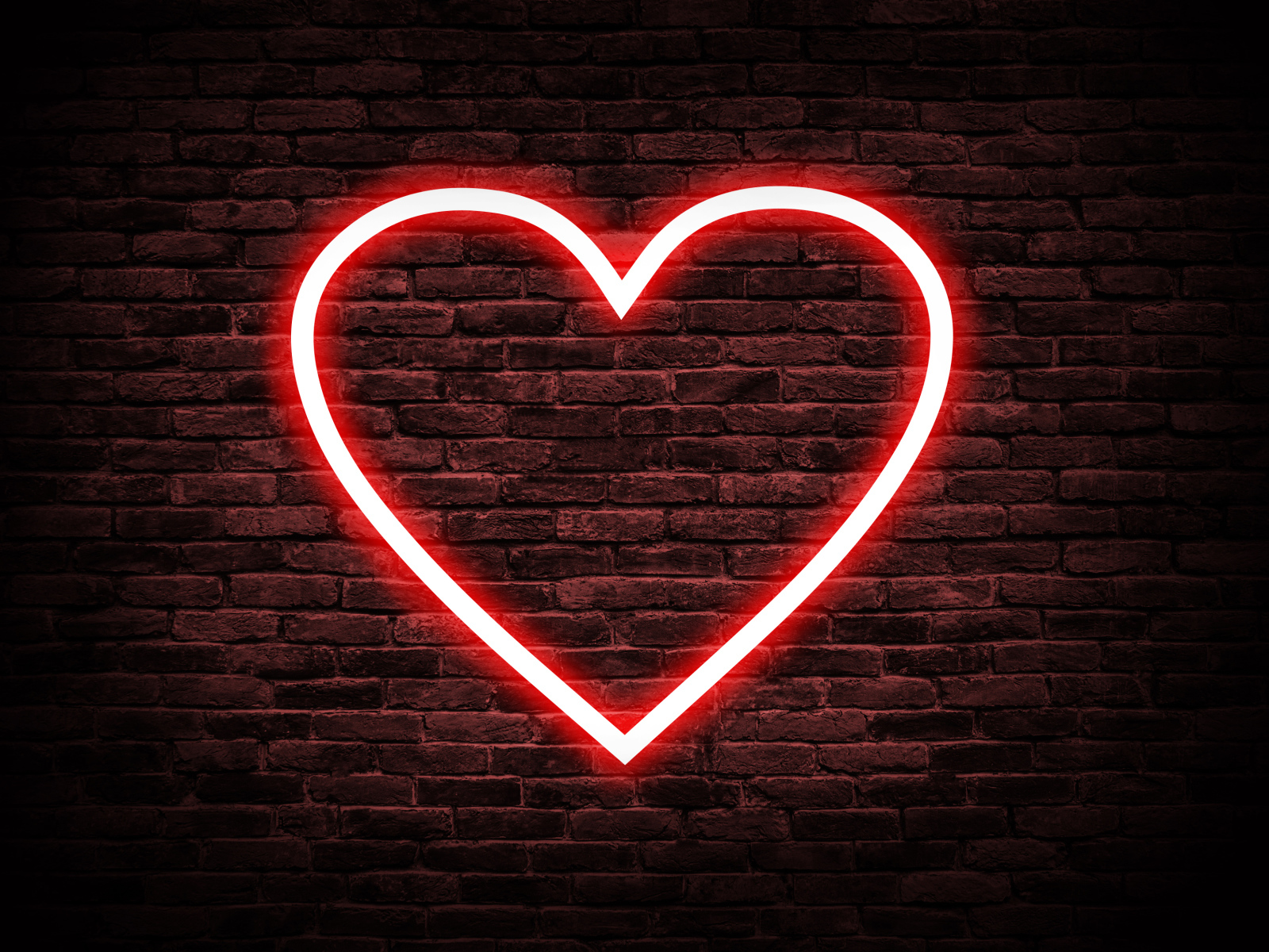 Красное неоновое сердце на кирпичной стене 