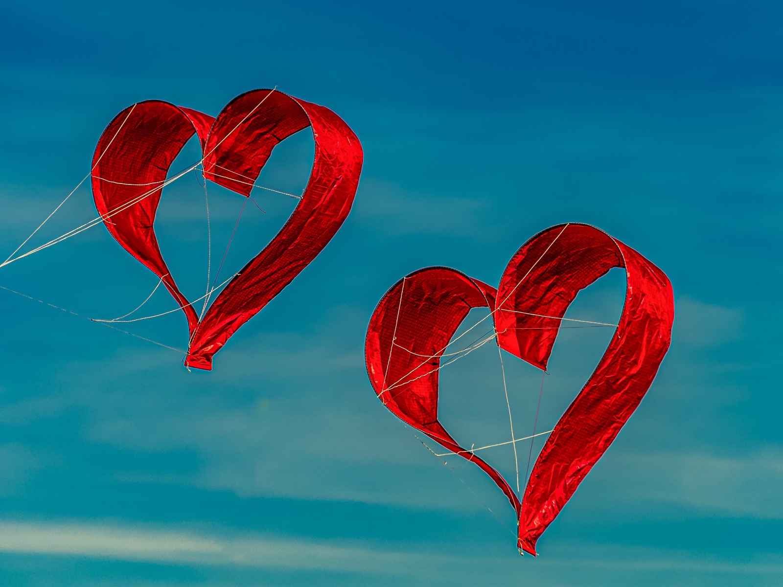 Два воздушных змея в форме сердца в небе