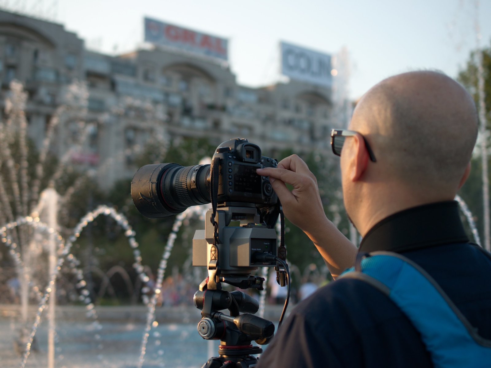 Мужчина снимает на камеру фонтан в парке