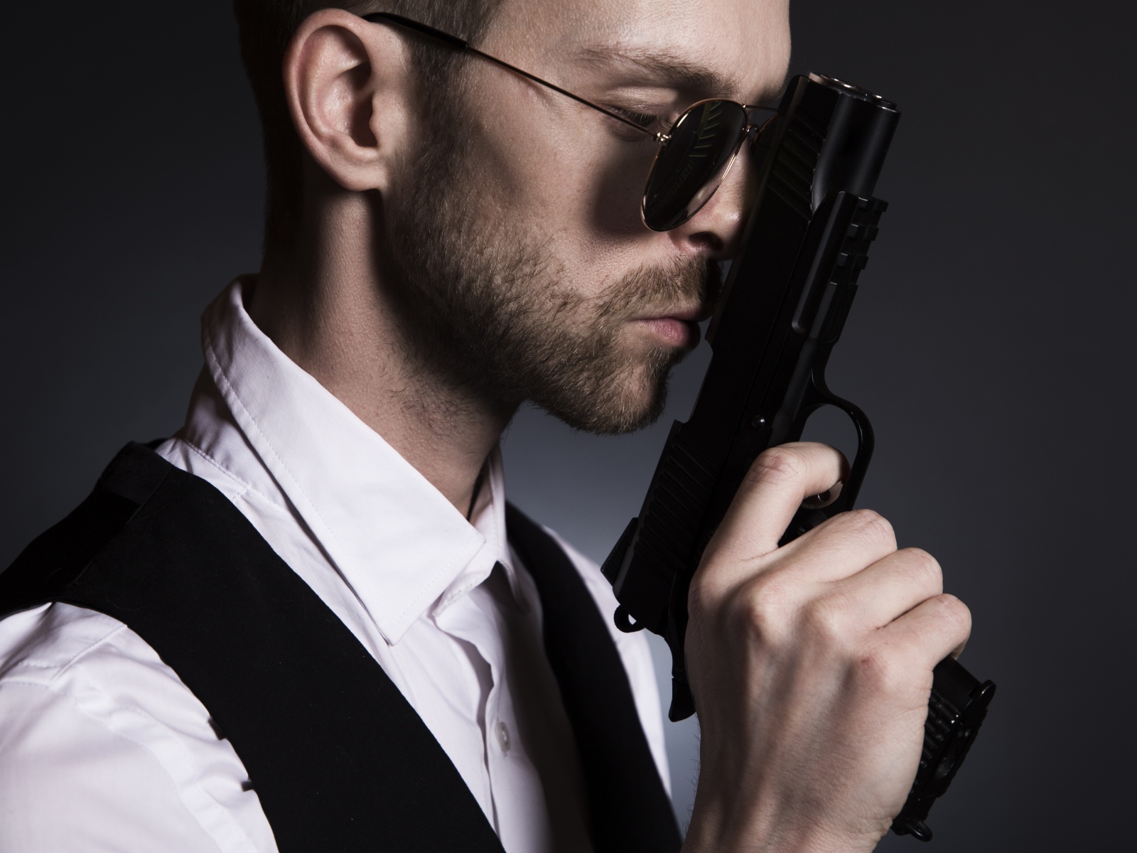 Мужчина в очках с пистолетом в руке