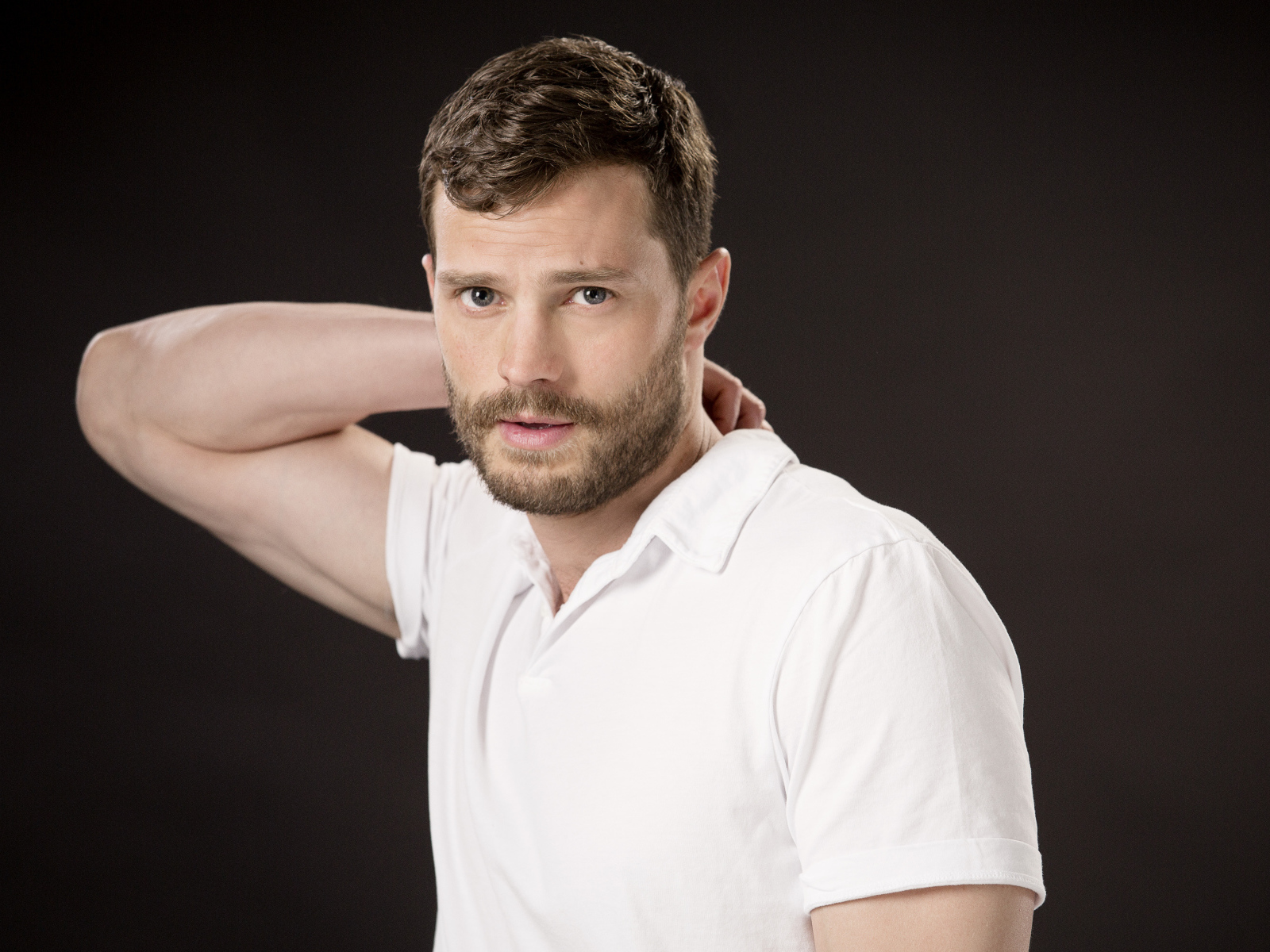 Актер Джейми Дорнан в белой рубашке на коричневом фоне