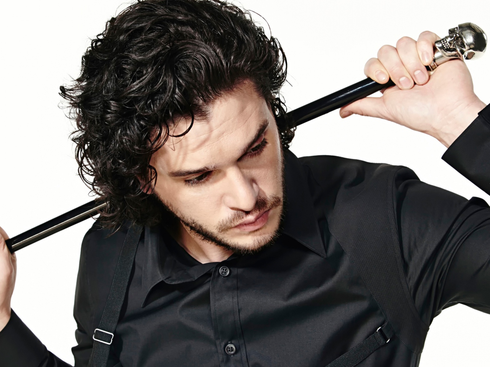 Актер Кит Хэрингтон с тростью в руках на белом фоне