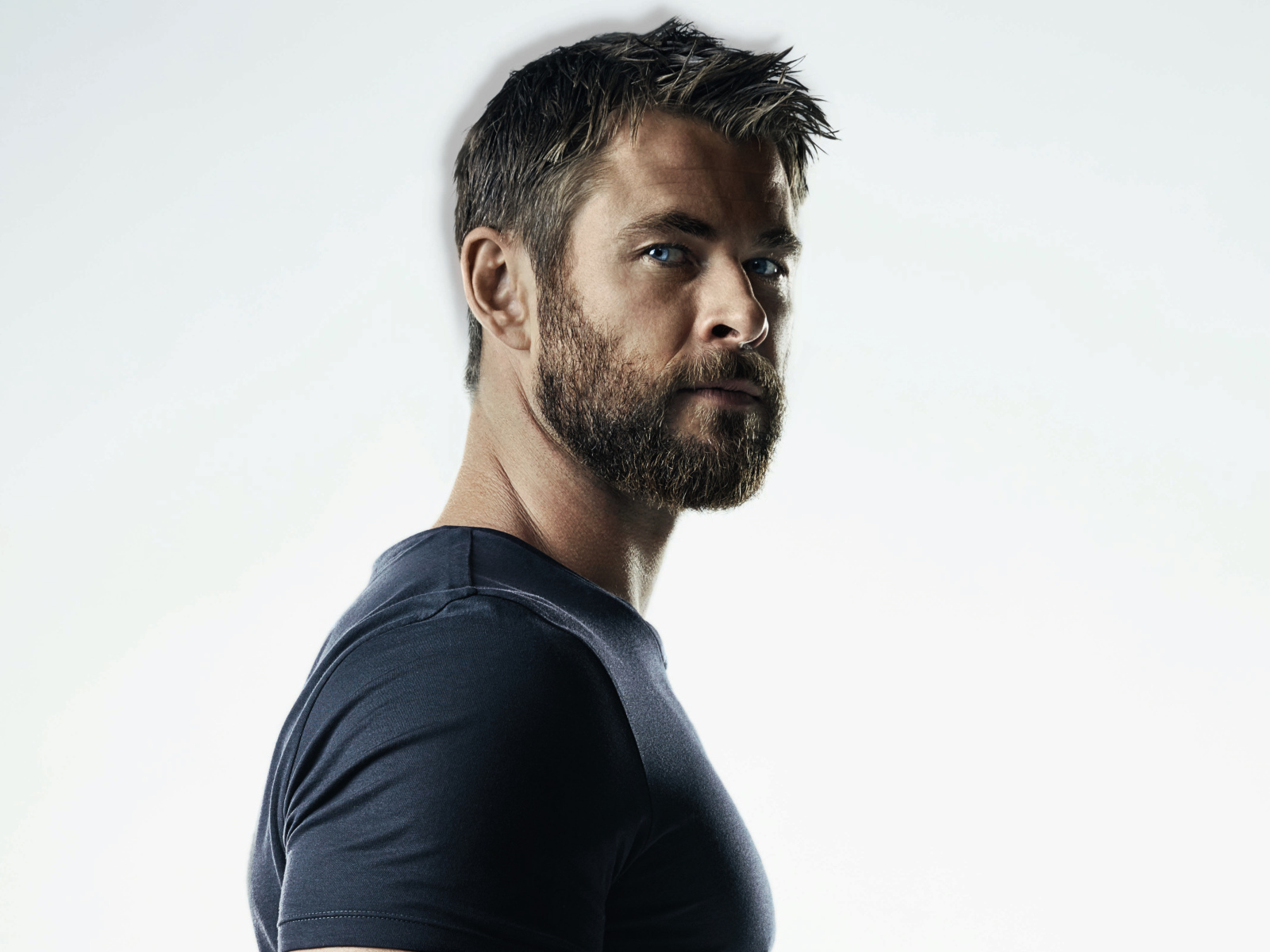 Красивый популярный актер Крис Хемсворт на сером фоне