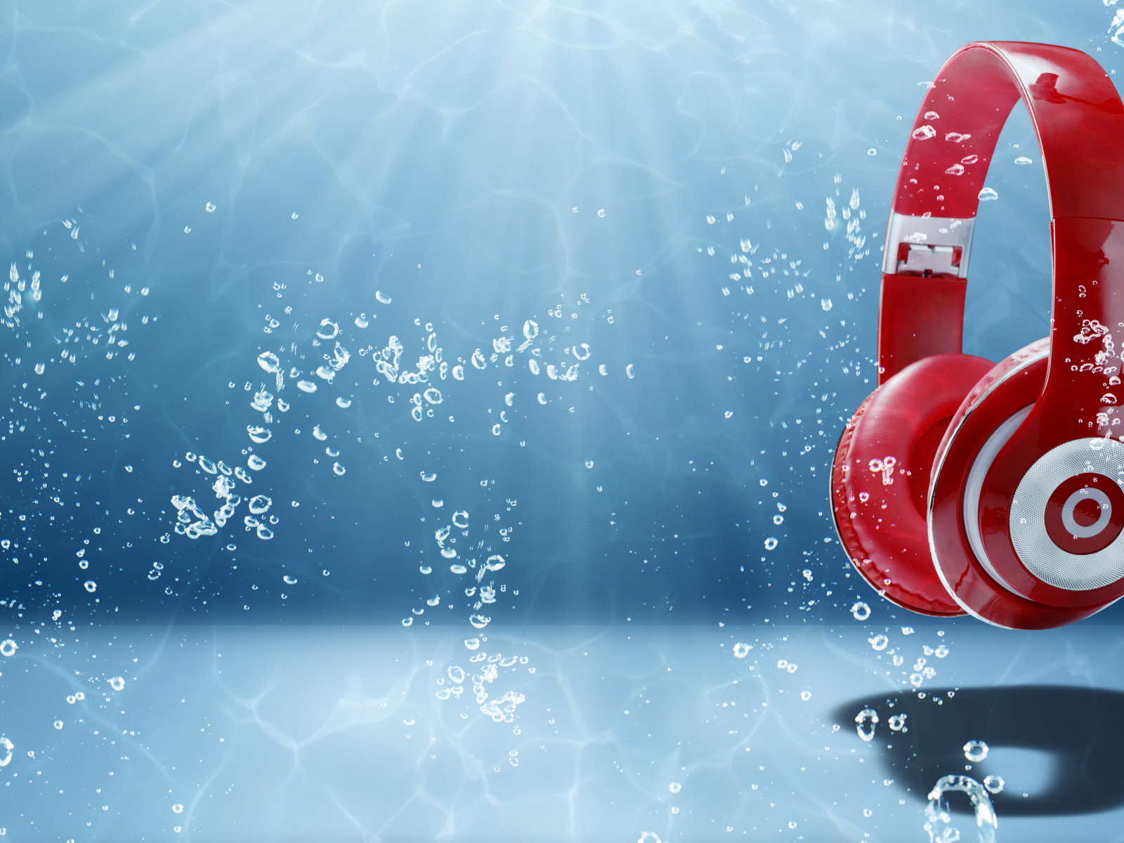 Большие красные наушники под водой на голубом фоне