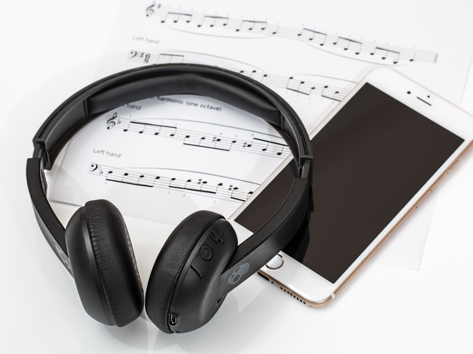 Наушники на столе с нотами и смартфоном