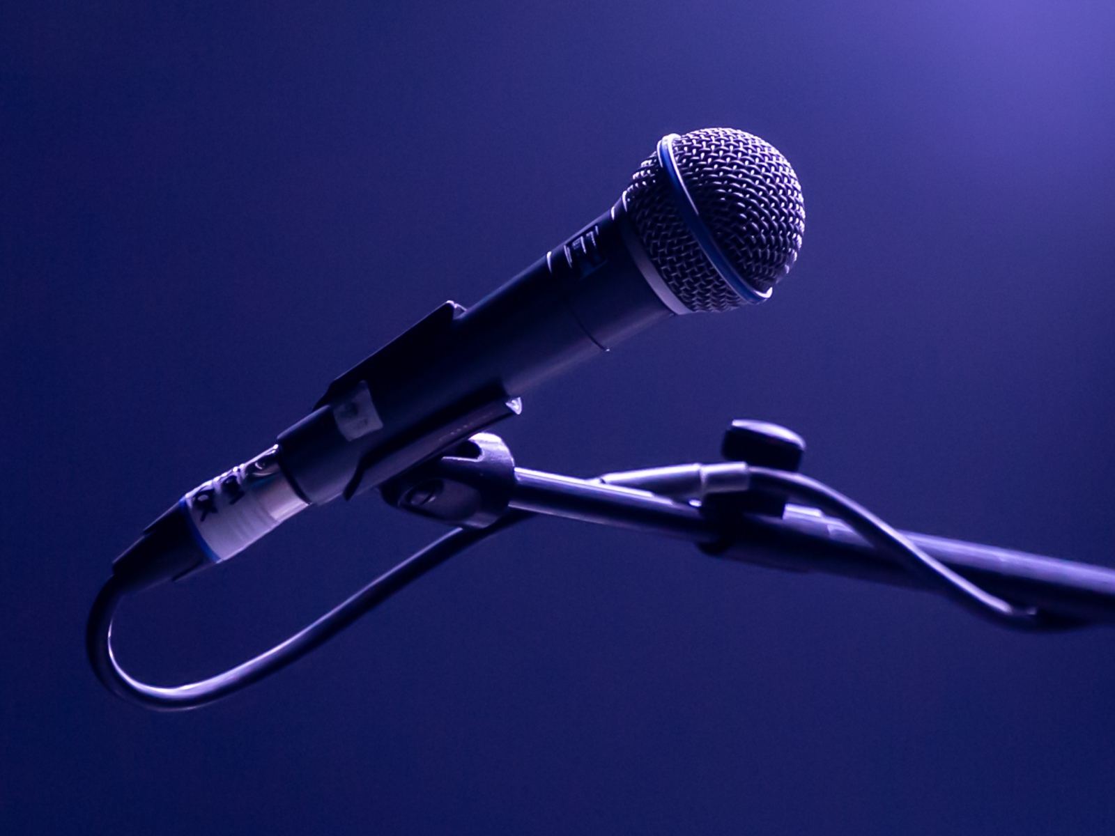 Микрофон на стойке на синем фоне