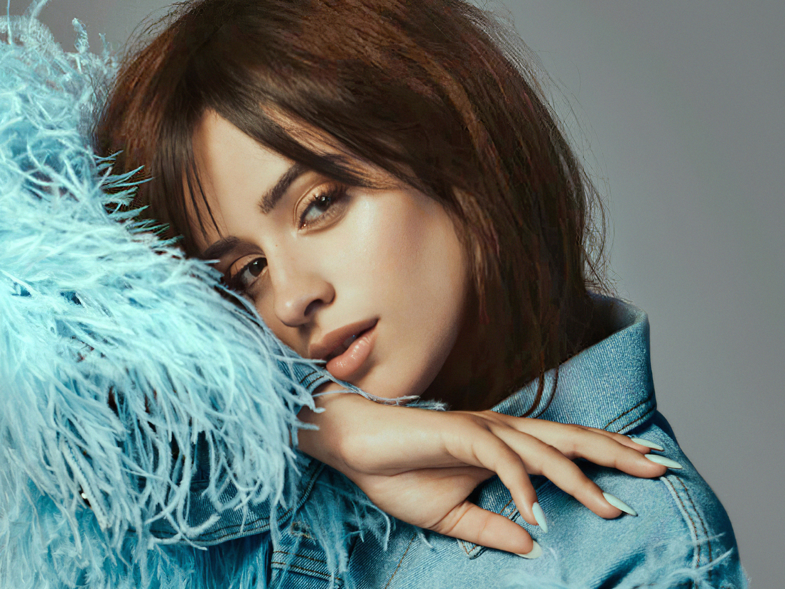 Певица Камила Кабельо в джинсовой куртке на сером фоне