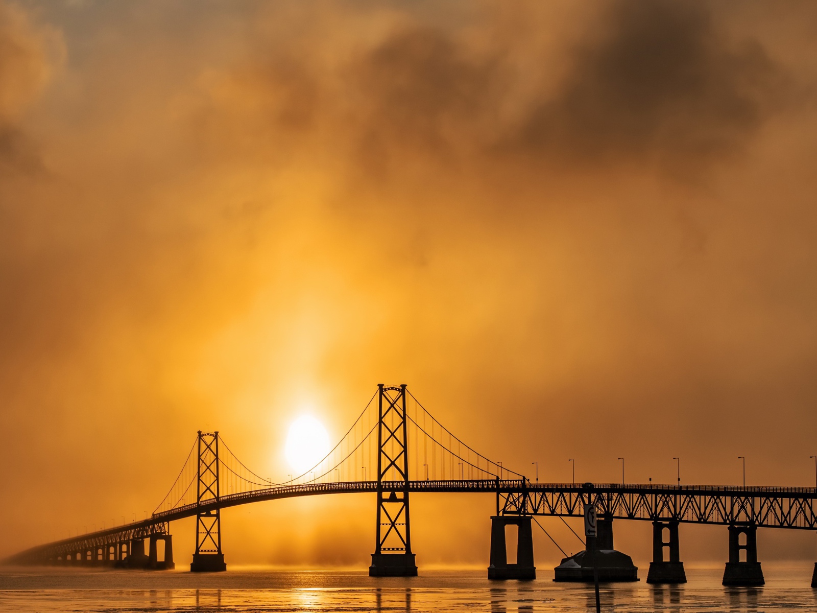 Мост через реку в тумане на восходе солнца