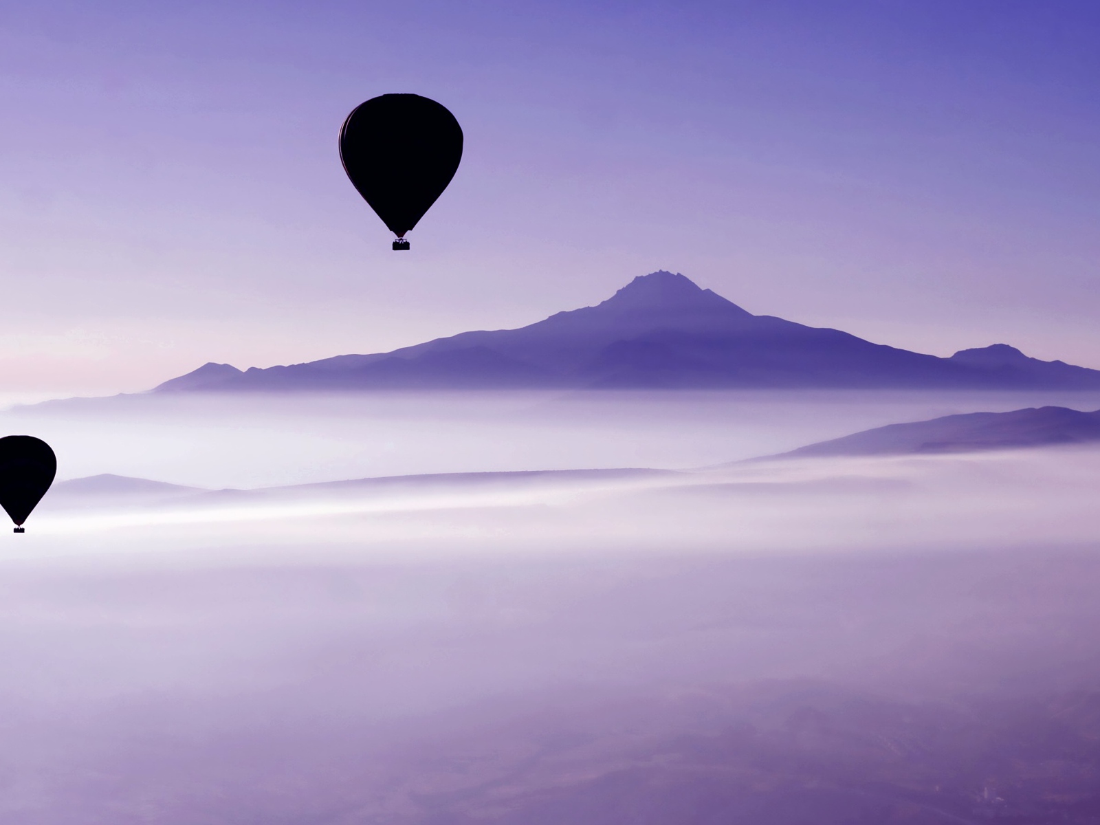 Два воздушных шара в небе над облаками