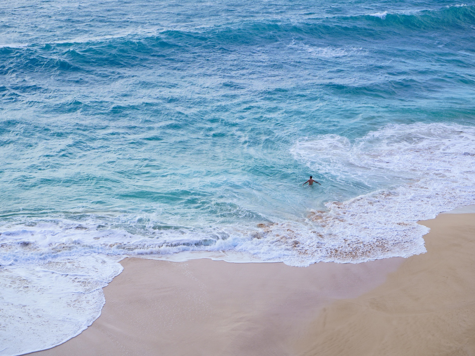 Голубая вода океана на пляже с желтым песком