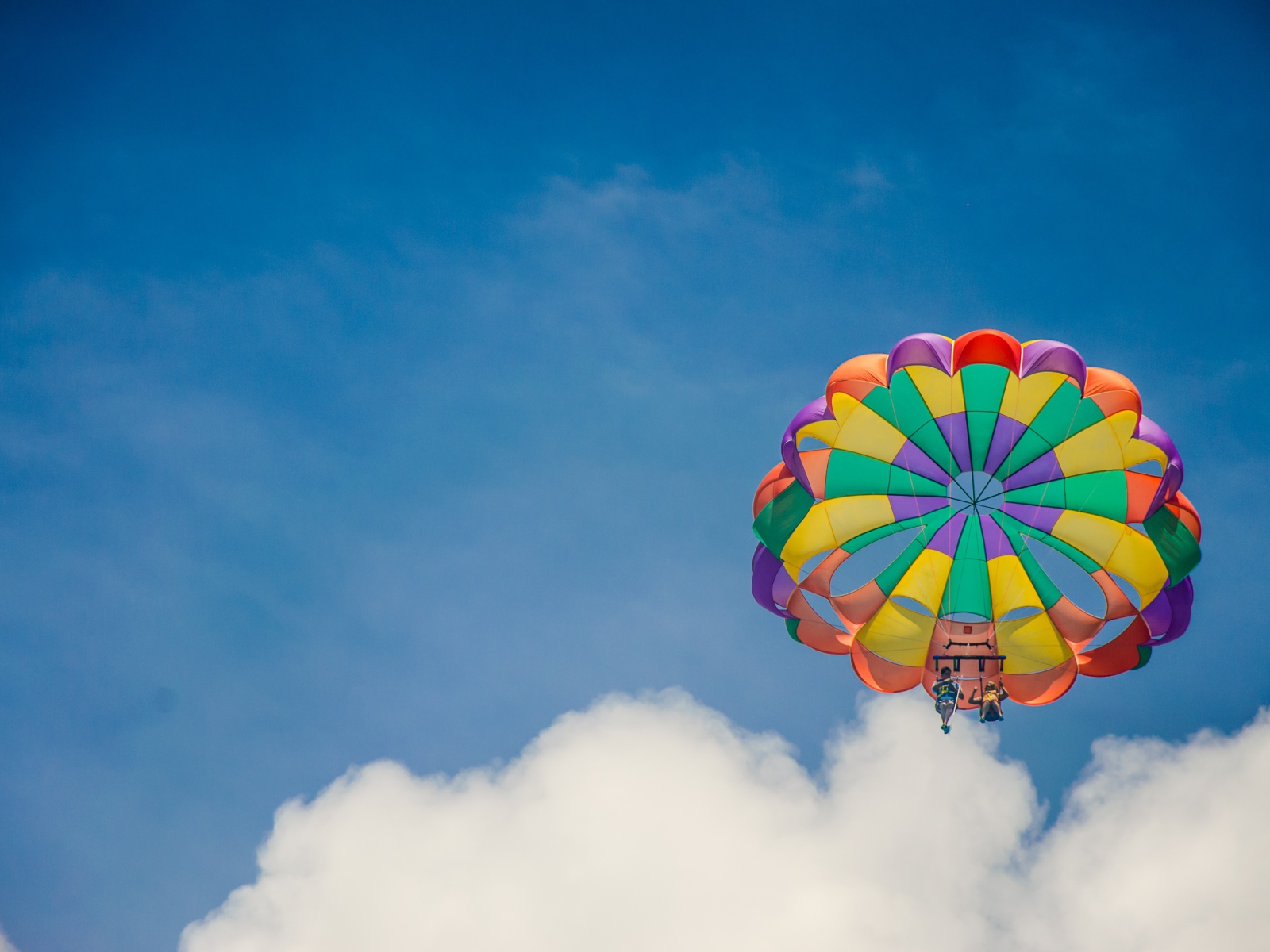 Парашют в голубом небе с белыми облаками