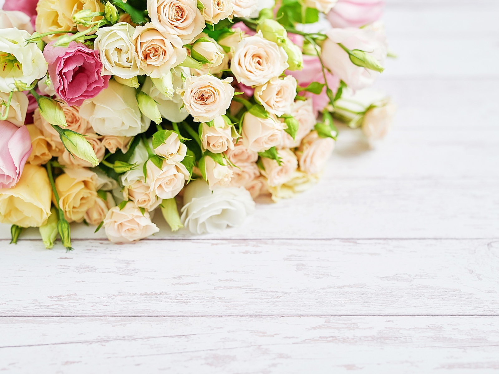 Красивый большой букет роз на белом столе