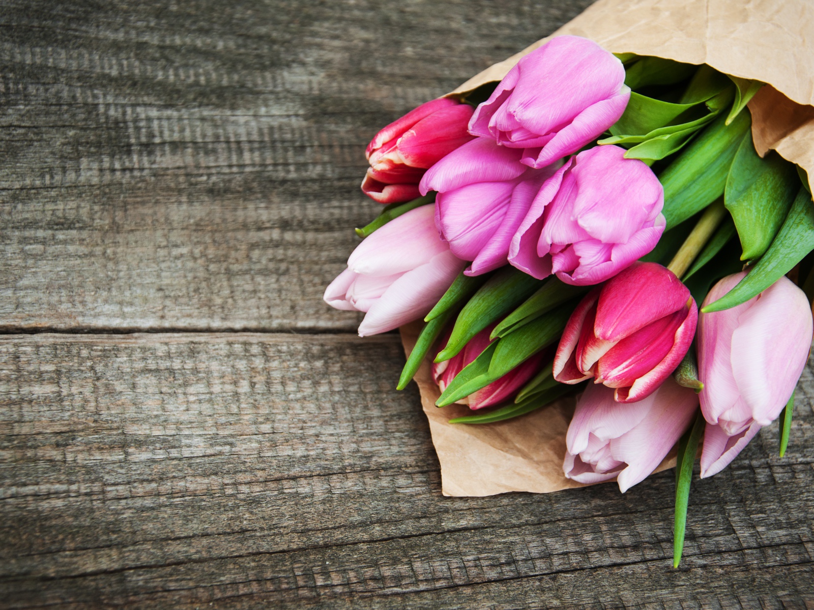 Букет розовых тюльпанов на деревянном столе 
