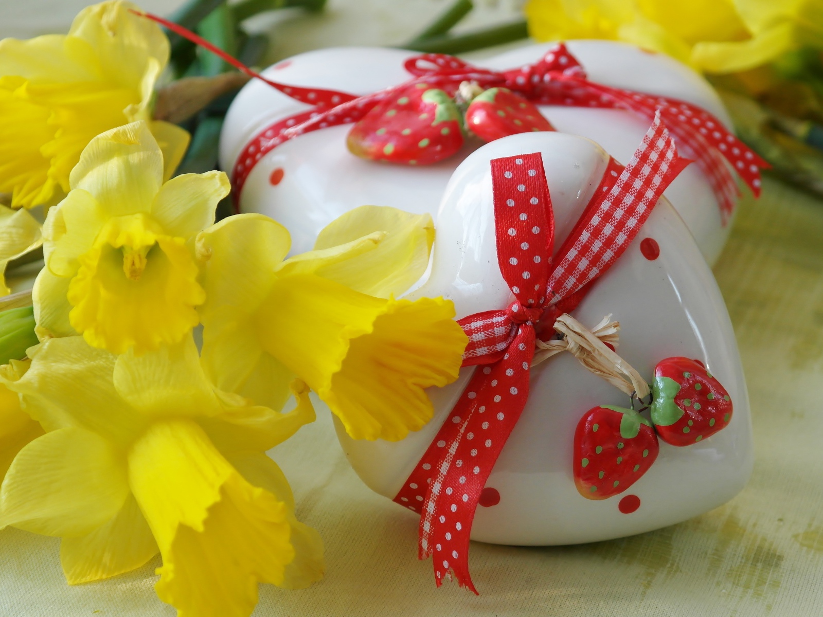Два белых фарфоровых сердца с букетом желтых нарциссов