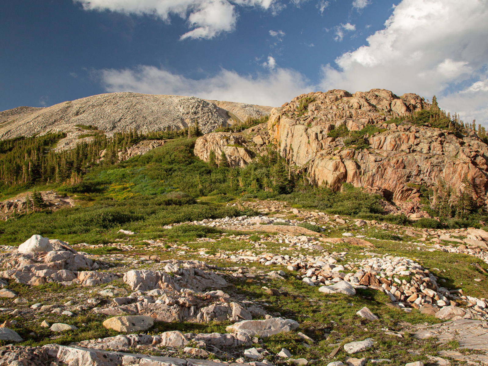 Высокие каменные горы под  голубым небом с белыми облаками