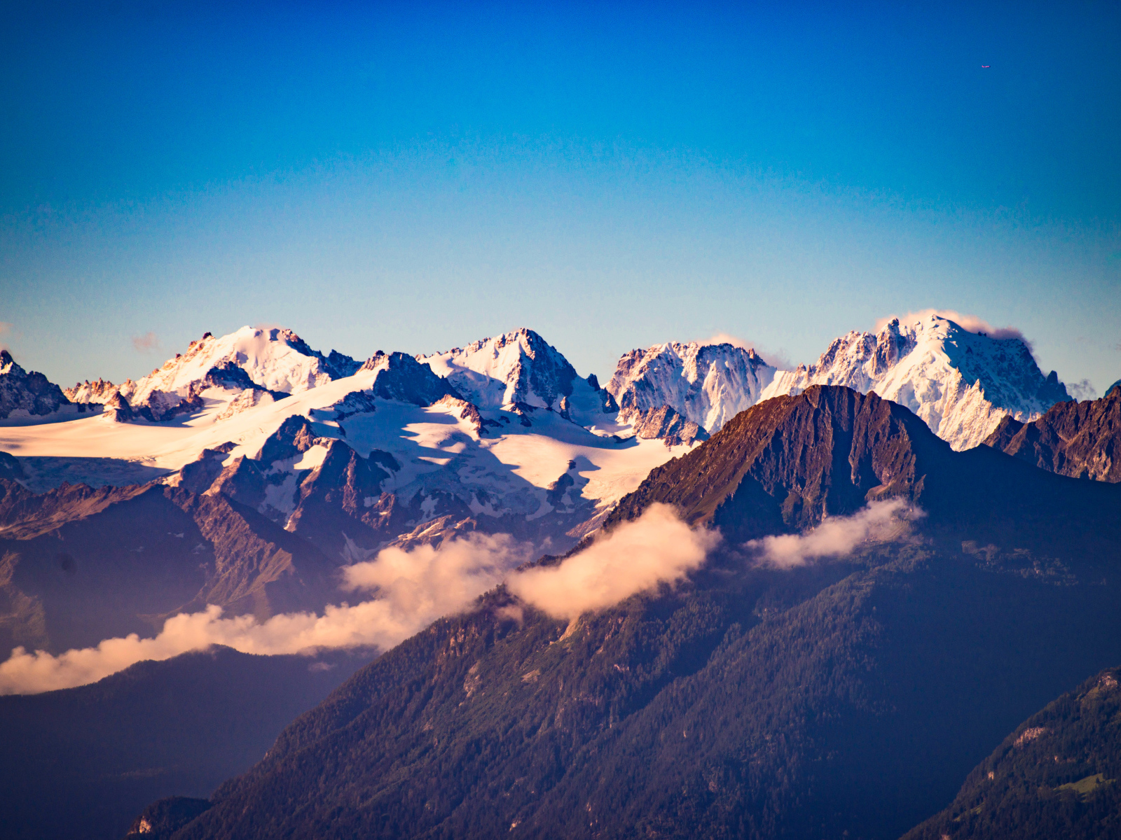 Заснеженные вершины гор под голубым небом