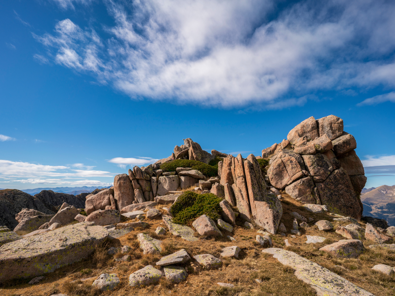 Каменные горы под голубым небом с белыми облаками 