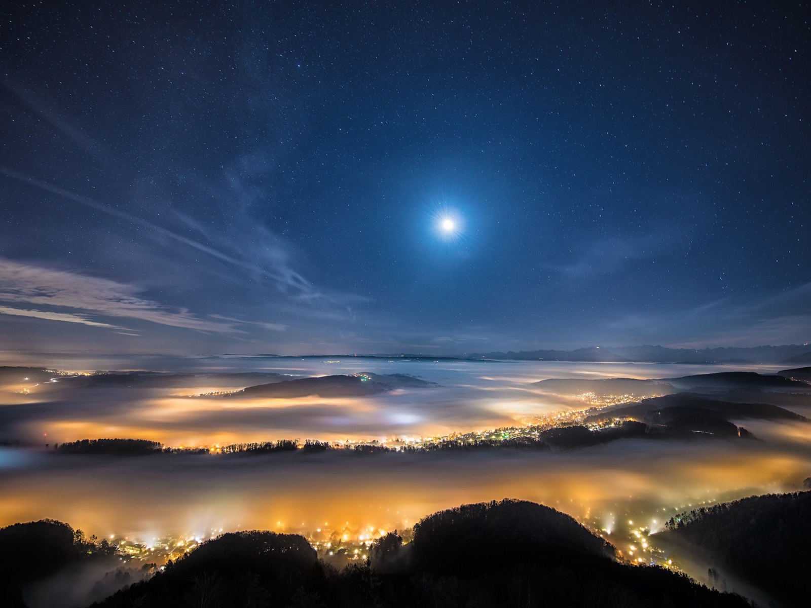 Вид с горы на покрытый туманом ночной город 